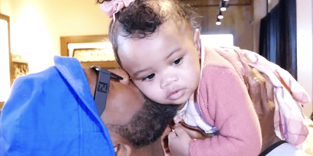 Man holding and kissing a baby.